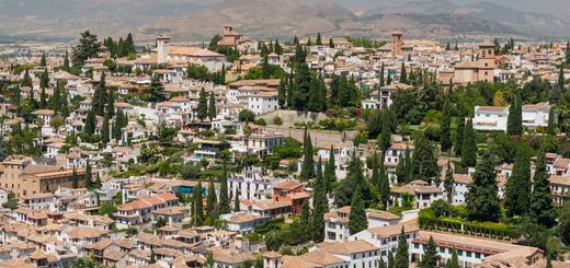 The white houses, tiled roofs and cypresses of the Albaicín hillside, seen from the Generalife gardens
