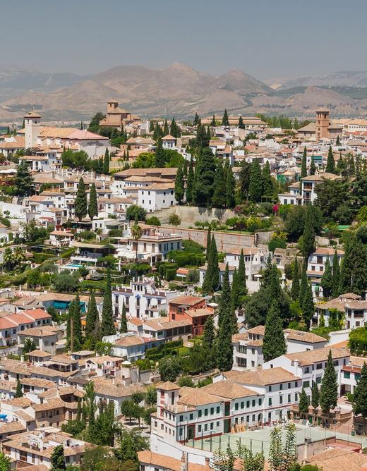The white houses, tiled roofs and cypresses of the Albaicín hillside, seen from the Generalife gardens